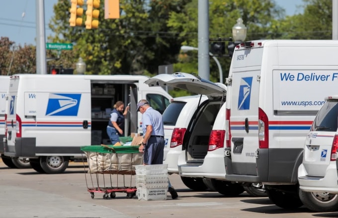 Nhân viên USPS chất thư lên các xe giao hàng bên ngoài một bưu cục ở Royal Oak, bang Michigan, ngày 22/8/2020. Ảnh: Reuters
