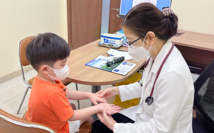 BS.CKI Trịnh Thị Thanh Ngân  khám cho trẻ mắc tay chân miệng tại Phòng khám Đa khoa Tâm Anh Quận 7. Ảnh: Minh Tâm