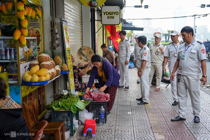 Lực lượng chức năng phường Hải Châu nhắc nhở các hộ kinh doanh vỉa hè, sau 31/3 sẽ bắt đầu xử phạt. Ảnh: Nguyễn Đông