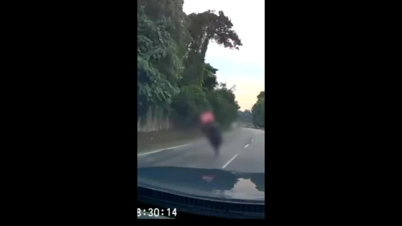 Xe máy thụt hố giữa đường ngã lộn vòng trước đầu ôtô