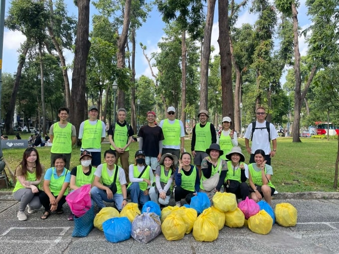 Anh Kenta Fuji (áo trắng, bìa phải) cùng đội tình nguyện dọn rác ở Công viên 30/4, TP HCM, sáng 29/3. Ảnh: Ngọc Ngân