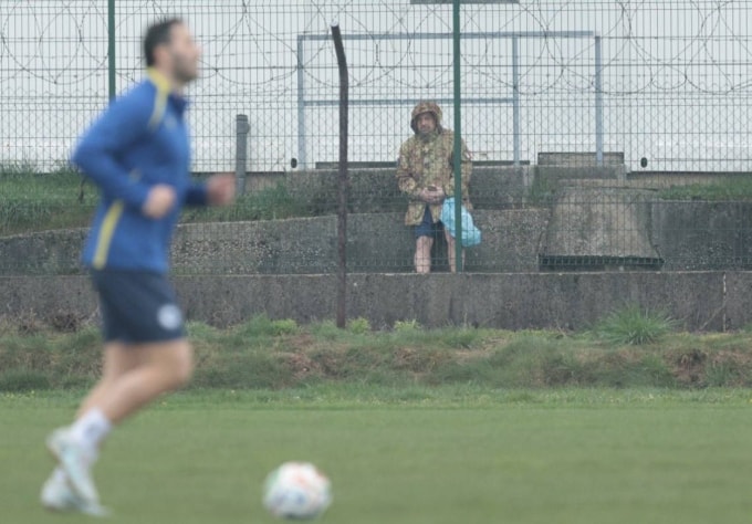 Người lính đứng ngoài hàng rào quay video buổi tập tuyển Bosnia & Herzegovina ở Butmir hôm 30/3. Ảnh: X