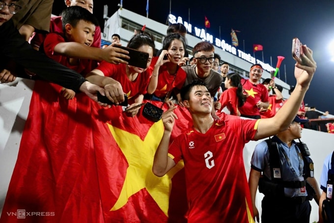 Trung vệ Đỗ Duy Mạnh chụp ảnh với khán giả sau trận thắng Malaysia. Ảnh: Giang Huy