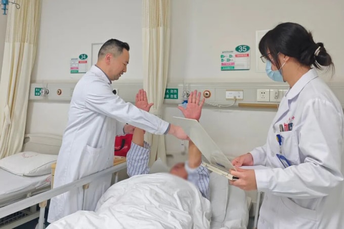 Bác sĩ Hùng Vĩ (bìa trái) đi buồng thăm khám bệnh nhân. Ảnh: Li Huizi