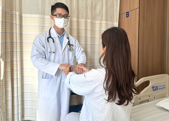 Bác sĩ Trọng đang kiểm tra vận động cho chị Mai trước khi xuất viện. Ảnh: Bệnh viện Đa khoa Tâm Anh