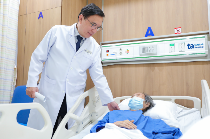 Giáo sư Nhân hỏi thăm sức khỏe bệnh nhân sau can thiệp. Ảnh: Bệnh viện Đa khoa Tâm Anh
