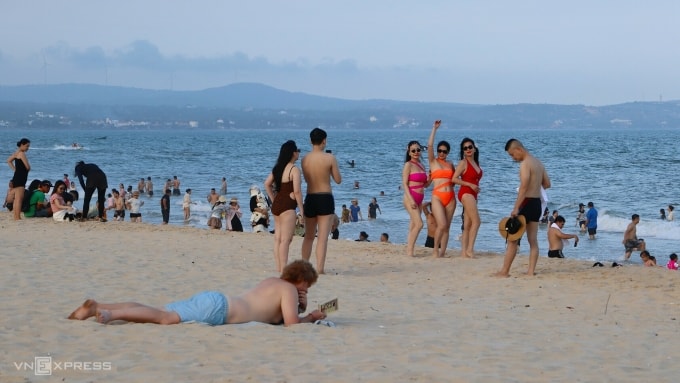 Du khách thư giãn trên bãi biển Mũi Né tháng 7/2025. Ảnh: Việt Quốc