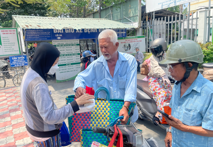 Ông Trung Hải phát cơm trước cổng Bệnh viện Lê Văn Thịnh, phường Bình Trưng, TP HCM, trưa 31/3. Ảnh: Ngọc Ngân