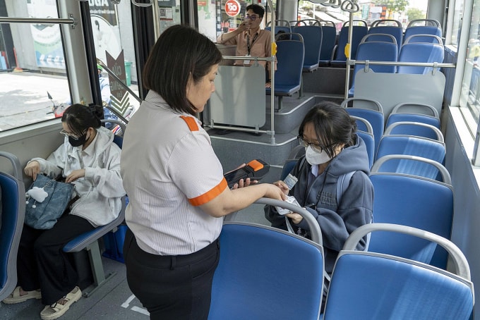 Nhân viên soát vé hành khách đi xe buýt ở TP HCM. Ảnh: Giang Anh