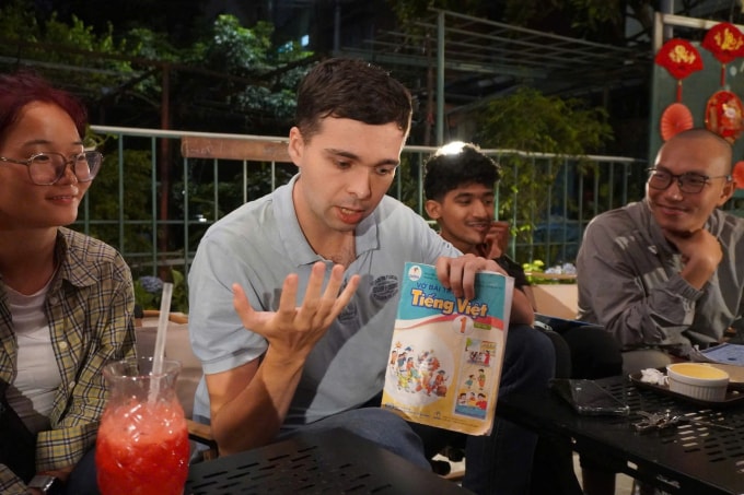 Một chàng trai người Đức đang cầm vở bài tập Tiếng Việt để ôn bài. Ảnh: Huy Khánh