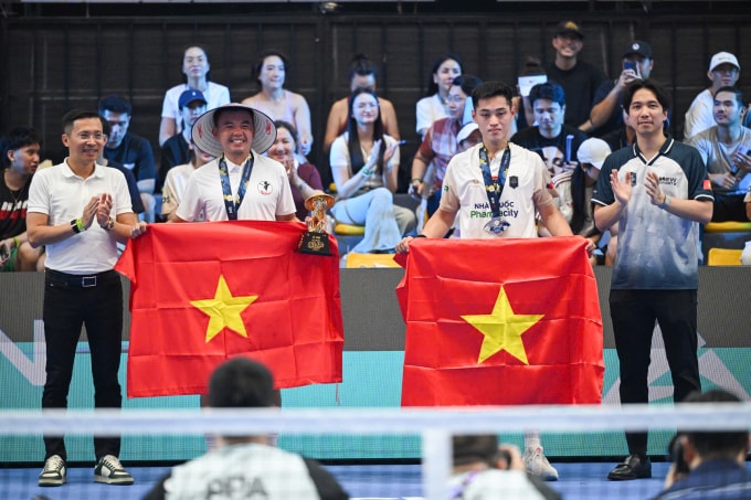 Hoàng Nam (trái) và Vinh Hiển cùng những lá cờ Việt Nam trên bục nhận giải, ở Cung điền kinh Mỹ Đình, Hà Nội hôm 5/4. Ảnh: Giang Huy