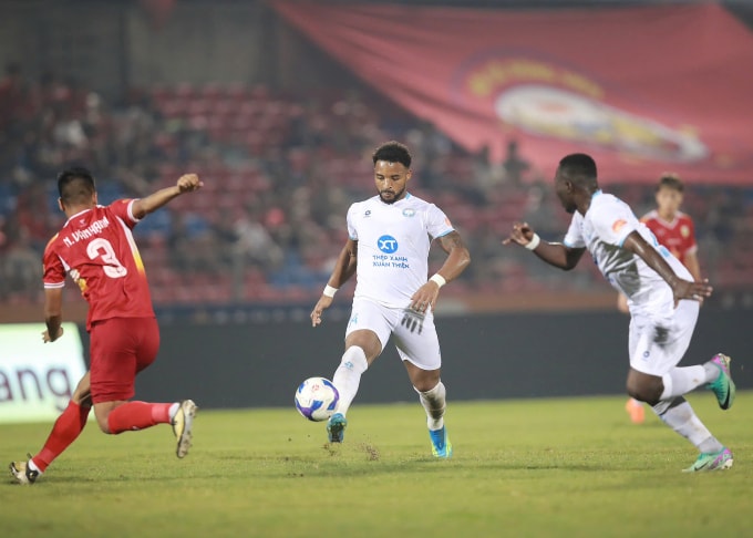 Nguyễn Xuân Son (giữa) kiến tạo cho Chadrac Akolo (phải) ấn định chiến thắng 2-0 cho Nam Định trước Hà Tĩnh. Ảnh: Quang Đương