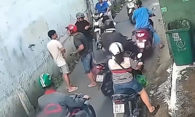 Người đàn ông mũ đỏ đánh nam thanh niên áo trắng khi bị can ngăn. Ảnh: Thái Hà