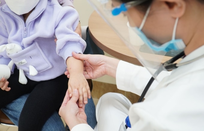 Bác sĩ đang khám cho trẻ nghi mắc tay chân miệng. Ảnh minh họa: Bệnh viện Đa khoa Tâm Anh