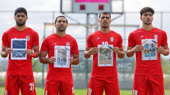 Cầu thủ Iran hát quốc ca, cầm ảnh những em nhỏ được cho là thiệt mạng trong các cuộc không kích của Mỹ và Israel tại Iran, trước trận giao hữu với Costa Rica tại Antalya, miền nam Thổ Nhĩ Kỳ, ngày 31/3/2026. Ảnh: AP