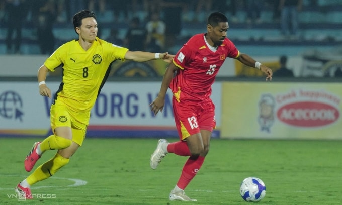 Tiền vệ Malaysia lai Anh Stuart Wilkin đuổi theo hậu vệ Việt kiều Pháp Cao Pendant Quang Vinh trong trận trên sân Thiên Trường tối 31/3/2026. Ảnh: Ngọc Thành