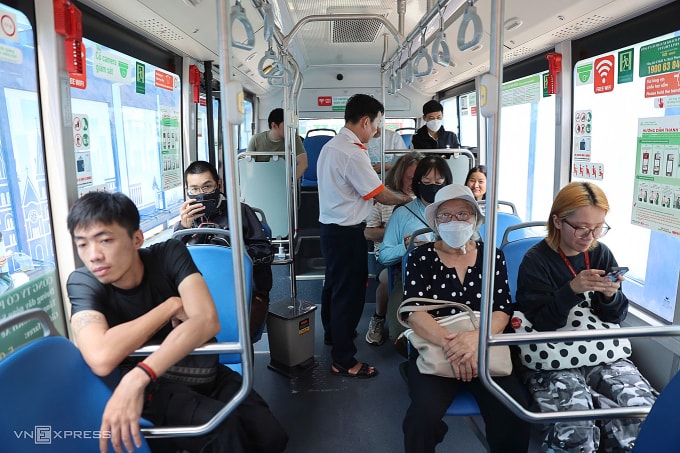 Nhân viên soát vé hành khách trên xe buýt. Ảnh: Quỳnh Trần