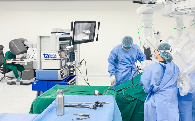 Phó giáo sư Vĩnh (bên trái) điều khiển robot Da Vinci Xi phẫu thuật cắt u tuyến ức cho người bệnh. Ảnh: Bệnh viện Đa khoa Tâm Anh
