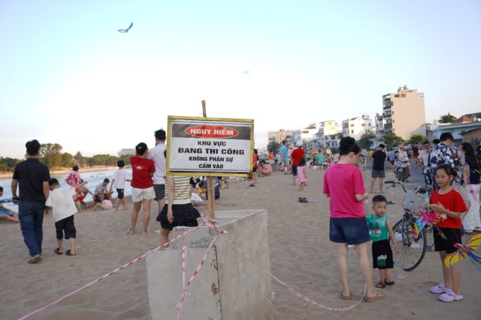 Người dân, du khách phớt lờ biển cảnh báo vào khu vực bãi cát để vui chơi. Ảnh: Tuấn Anh