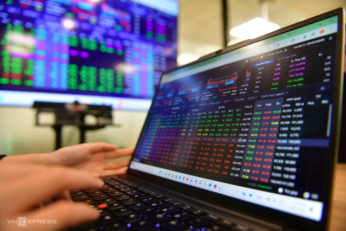 Nhà đầu tư theo dõi bảng giá chứng khoán tại một công ty ở TP HCM. Ảnh: Thanh Tùng