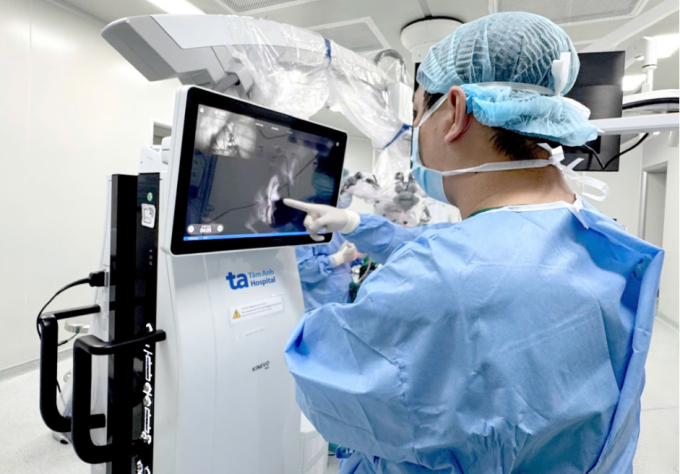 Bác sĩ Vũ đang kiểm tra lưu thông mạch máu bằng kỹ thuật chụp huỳnh quang của kính vi phẫu sau khi kẹp túi phình. Ảnh: Bệnh viện Đa khoa Tâm Anh