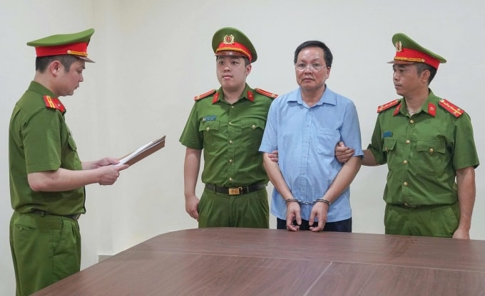 Công an đọc lệnh khởi tố ông Vũ Doanh Nam. Ảnh: Công an cung cấp