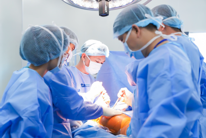 Bác sĩ Vũ (giữa) cùng êkíp phẫu thuật thay khớp háng cho bệnh nhân. Ảnh: Bệnh viện Đa khoa Tâm Anh