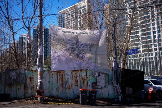 Bản đồ tái quy hoạch treo ngoài lối vào làng Guryong hồi tháng 3. Ảnh: NYT