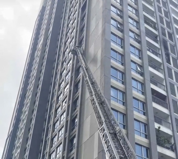 Lính cứu hỏa giương thang cao gần 15 m để tiếp cận căn hộ cháy dập lửa. Ảnh: Minh Bằng