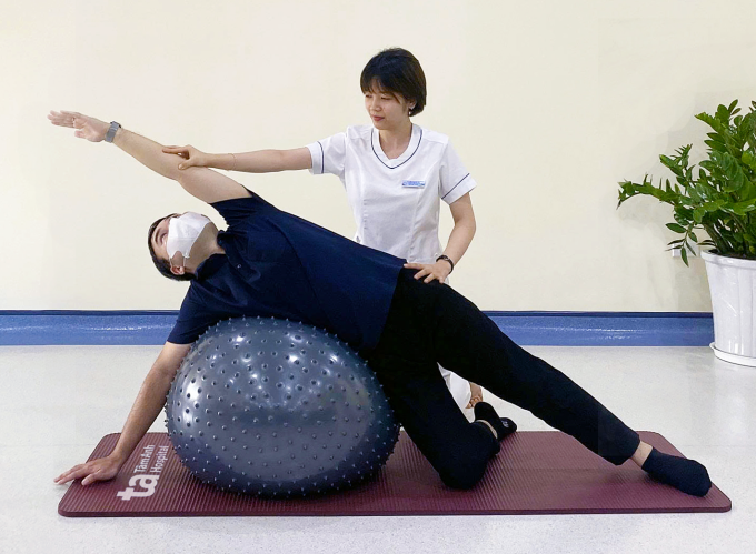 Chuyên gia vật lý trị liệu hướng dẫn người thoái hóa cột sống tập luyện với bóng. Ảnh: Phòng khám Đa khoa Tâm Anh Cầu Giấy