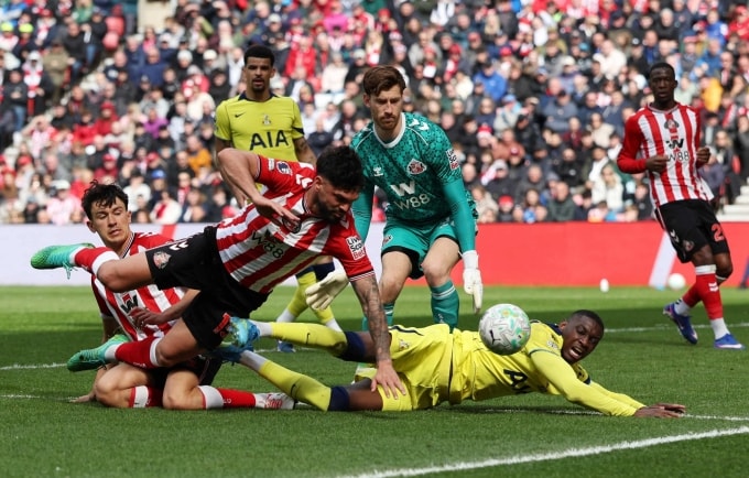 Tiền đạo Tottenham Randal Kolo Muani ngã khi tranh chấp với hai cầu thủ Sunderland Omar Alderete và  Luke O’Nien. Ảnh: Reuters