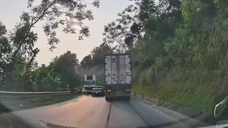 Xe con mắc kẹt giữa hai xe tải ở khúc cua