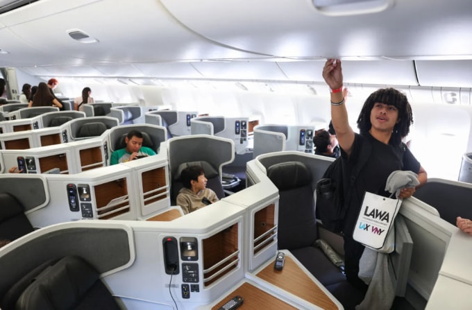 Một hành khách đang chỉnh lỗ thông gió trên khoang máy bay. Ảnh: AFP