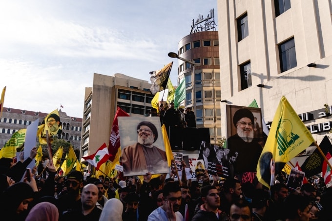 Người biểu tình cầm ảnh cố lãnh đạo Hezbollah Hassan Nasrallah và vẫy cờ Hezbollah tại quảng trường Riad Al Solh ở Beirut, Lebanon, ngày 11/4, để phản đối đàm phán hòa bình với Israel. Ảnh: AFP