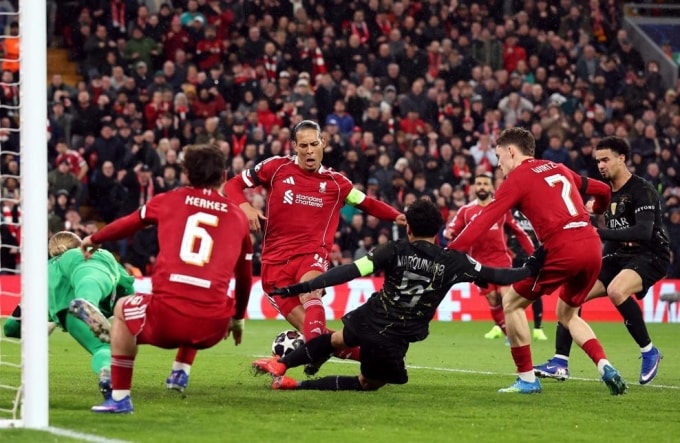 Marquinhos (đen) chơi lăn xả, ngăn Van Dijk (đội trưởng, đỏ) ghi bàn, trên sân Anfield, Liverpool, Anh hôm 14/4. Ảnh: Reuters