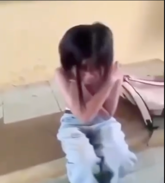 Nạn nhân bị lột áo, liên tục chắp tay van xin, che ngực. Ảnh cắt từ clip