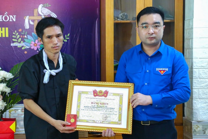 Ông Lê Anh Tuấn (bố của Quỳnh Chi, góc trái), nhận huy hiệu Tuổi trẻ dũng cảm từ lãnh đạo Tỉnh đoàn Nghệ An, sáng 15/4. Ảnh: Hùng Lê