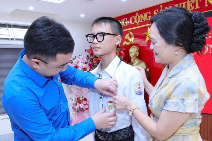 Em Võ Hoàng Thành (đứng giữa), nhận huy hiệu Tuổi trẻ dũng cảm. Ảnh: Hùng Lê