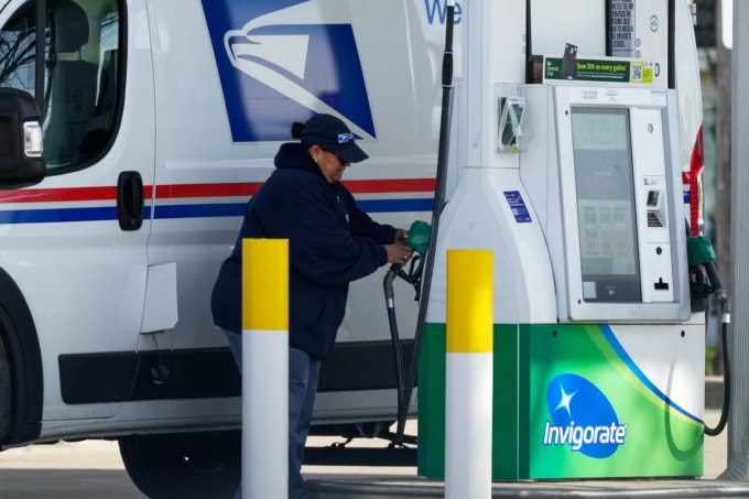 Nhân viên cơ quan Dịch vụ Bưu chính Mỹ (USPS) đổ xăng tại một trạm bơm ở Chicago ngày 7/4. Ảnh: AP