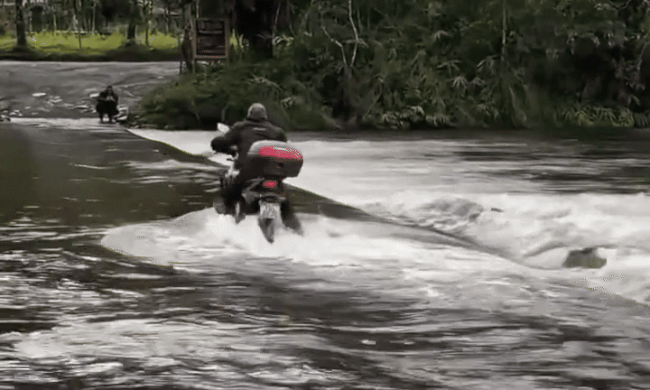 Tay lái môtô suýt bị cuốn trôi khi chạy qua cầu ngập nước