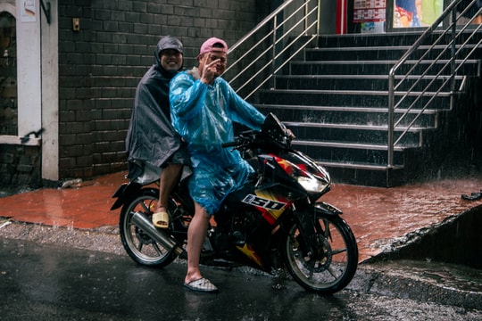 Khách nước ngoài đội mưa quay Hà Nội ngập