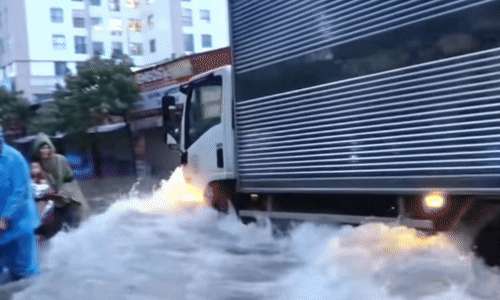 Lao nhanh qua vùng ngập nước, xe tải xô ngã nhiều xe máy