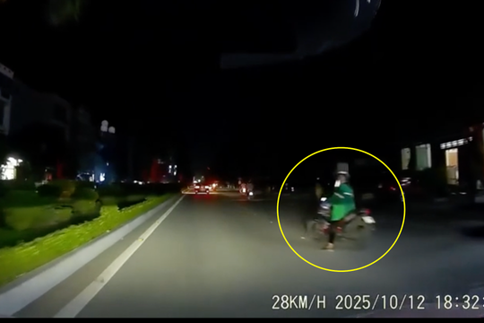 Người phụ nữ dừng xe máy giữa đường nghe điện thoại