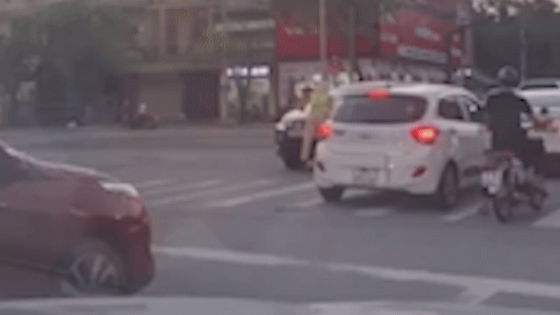 Cảnh sát giao thông bị hất lên capo