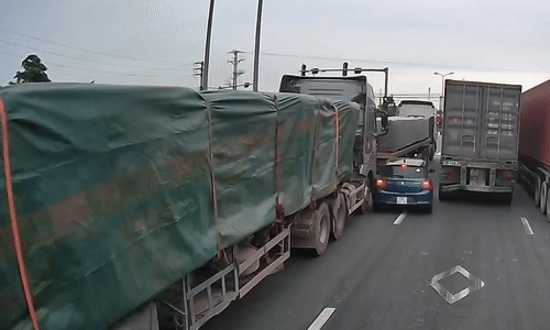 Chen vào khe hẹp, ôtô con bị kẹp giữa hai xe đầu kéo