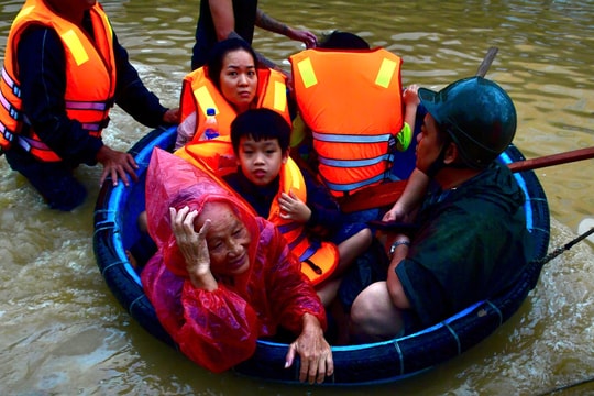 Người dân bám dây, ngồi thúng thoát khỏi lũ xiết