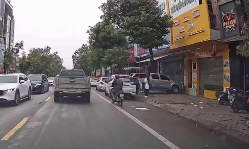 Cửa ôtô mở trúng người đi xe máy nghe điện thoại