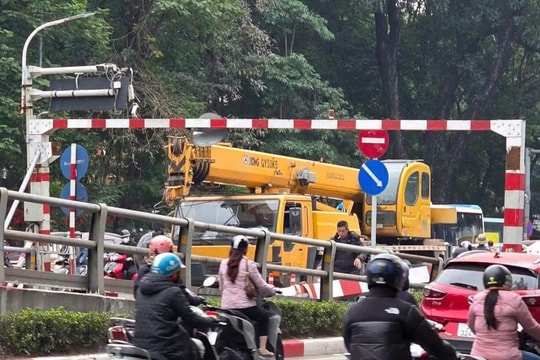 Xe cẩu húc đổ thanh chắn trên cầu vượt, rơi trúng hai xe máy