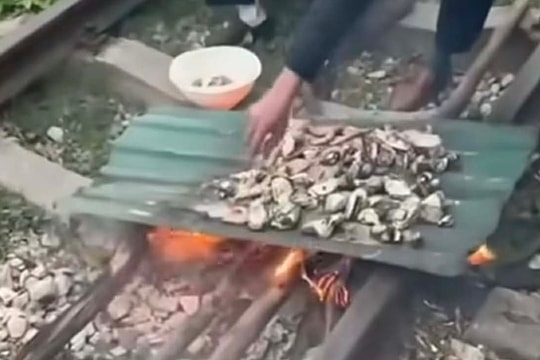Đôi vợ chồng đốt lửa nướng đồ ăn trên đường sắt Quảng Ninh