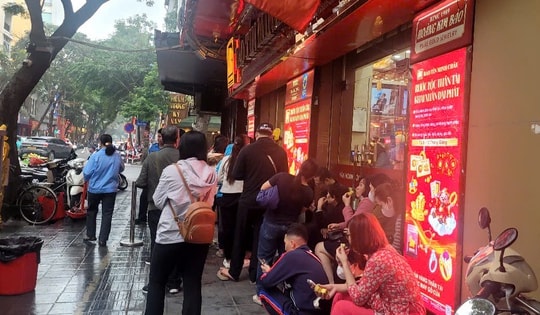 Người dân đội mưa xếp hàng chờ mua vàng trước ngày vía Thần Tài